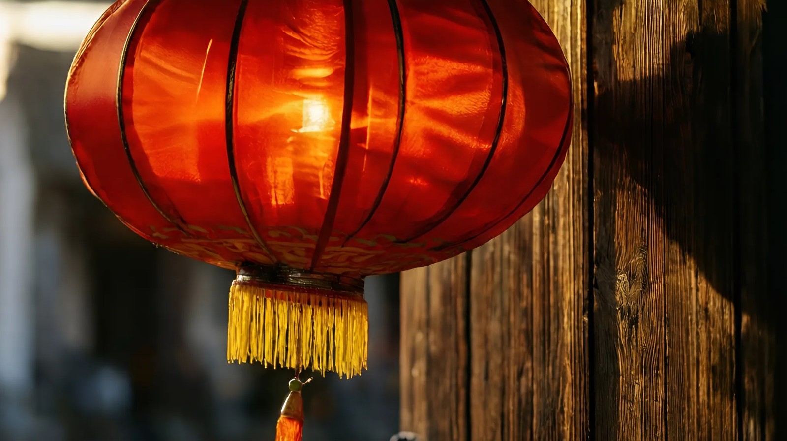Lanterna vermelha chinesa pendurada em portão de madeira, luz dourada passando pelo tecido