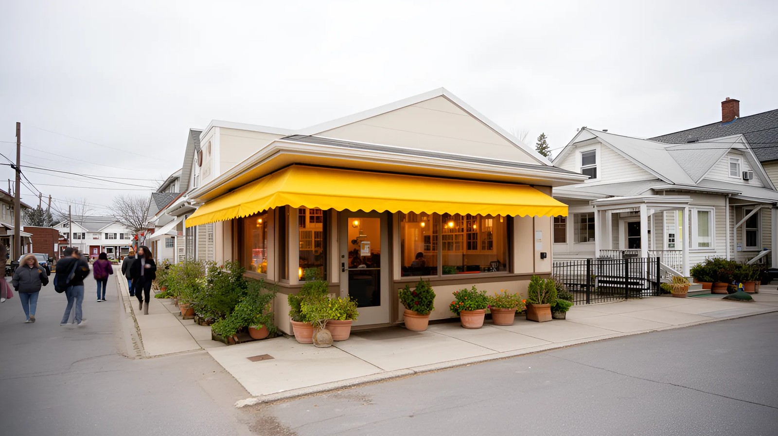 Fachada de restaurante de bairro com toldo amarelo e plantas, luz acolhedora nos vidros